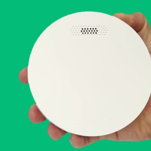 ZEN photoelectric smoke alarm - hand holding with green background