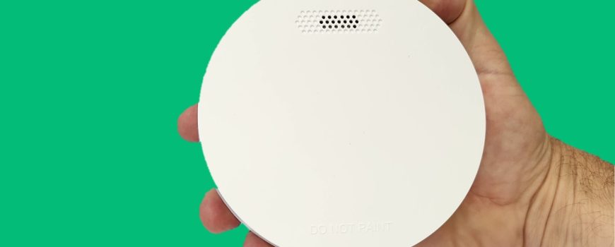 ZEN photoelectric smoke alarm - hand holding with green background